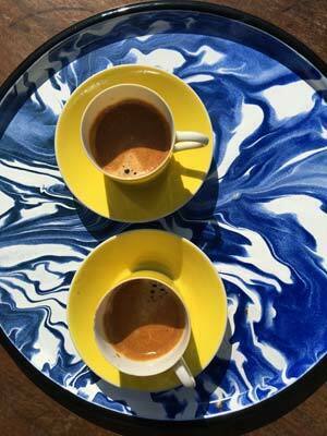 Tasses à café jaunes sur un plateau bleu et blanc lors d'un voyage au Portugal