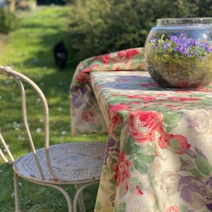 nappe fleurie à motifs roses et iris sur une table dans un jardin